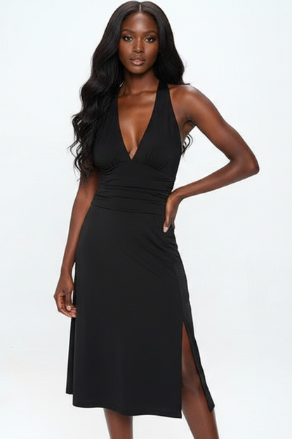 Woman wearing a black dress with a plunging neckline and side slit on a white background