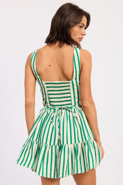 Woman wearing a green and white striped dress on a white background