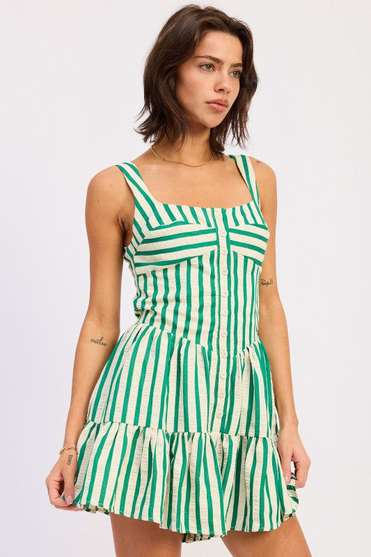 Woman wearing a green and white striped dress on a plain background