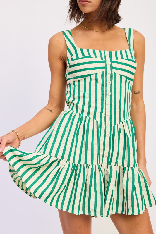 Green and white striped dress worn by a person on a light gray background