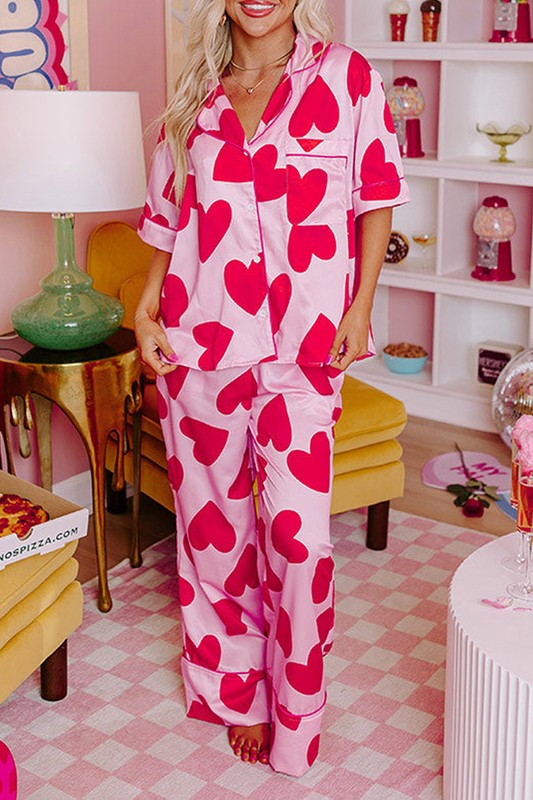 Woman wearing pink heart-patterned pajamas in a room with a checkered floor.