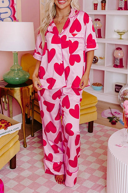 Woman wearing pink heart-patterned pajamas in a room with a checkered floor.